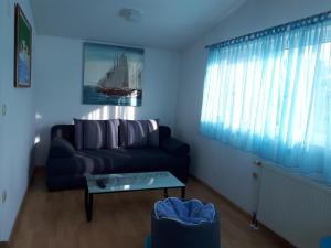 Sala de estar azul con sofá y mesa en Apartments Rinčić, en Marina