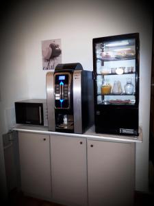 a microwave and a coffee maker on a counter with a refrigerator at Aux Chambres du Mont in Huisnes-sur-Mer