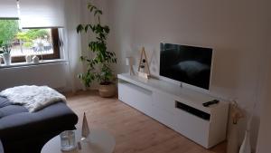 a living room with a flat screen tv on a white cabinet at Gästewohnung Flora in Taucha