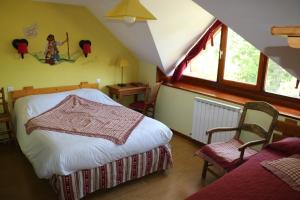 Villar-dʼArèneにあるAuberge Aux 3 Frenesのベッドルーム1室(ベッド1台、屋根裏部屋の椅子2脚付)