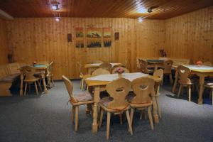 jadalnia ze stołami i krzesłami oraz drewnianymi ścianami w obiekcie Chiemgau Appartements w mieście Inzell