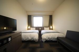 Ein Bett oder Betten in einem Zimmer der Unterkunft Dormy Inn Korakuen
