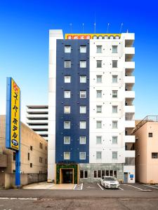 ein Gebäude mit einem davor geparkt in der Unterkunft Super Hotel Takamatsu Kin en kan in Takamatsu