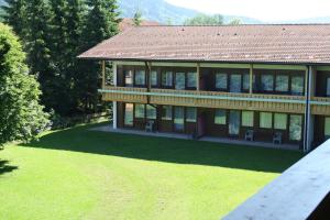 a large house with a large yard with green grass at Chiemgau Appartements in Inzell