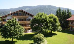 an apartment building with trees in front of a mountain at Chiemgau Appartements in Inzell