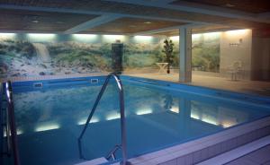 a large swimming pool with a mural of a waterfall at Chiemgau Appartements in Inzell