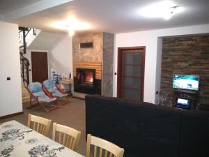 a living room with a table and chairs and a fireplace at Къща за гости "Мечта" in Lyutibrod