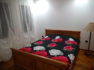 um quarto com uma cama com flores vermelhas em Къща за гости "Мечта" em Lyutibrod