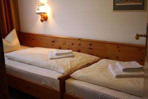 two beds in a room with towels on them at Chiemgau Appartements in Inzell