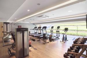 a gym with a bunch of treadmills and chairs at Baan mai khao apartment in Mai Khao Beach