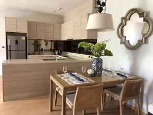 a kitchen with a wooden table and a dining room at Baan mai khao apartment in Mai Khao Beach