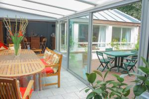 giardino d'inverno con tavolo e sedie su un patio di chambre d'hôte M et Mme Collet a Lille