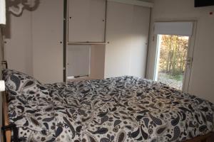 a bedroom with a bed with a black and white blanket at B&B De Rumelshof in Hierden