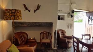 a living room with leather chairs and a table at Casa Tia Anica in Monsaraz