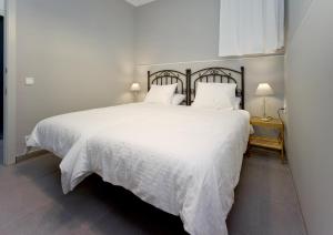巴塞隆納的住宿－Amplio apartamento con terraza en zona muy tranquila，卧室配有白色床单和白色大床
