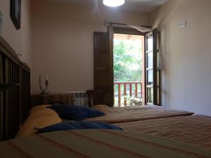 a bedroom with two beds and a window at Apartamentos Rurales Buenamadre in Pola de Somiedo