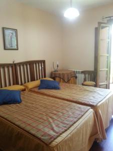 a bedroom with a large bed with blue pillows at Apartamentos Rurales Buenamadre in Pola de Somiedo