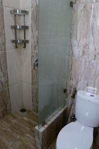 a bathroom with a toilet and a glass shower at Diyar Villas Puncak F4/8 in Puncak