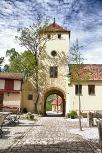 um grande edifício com uma arcada num pátio em Wildberghof em Markt Nordheim