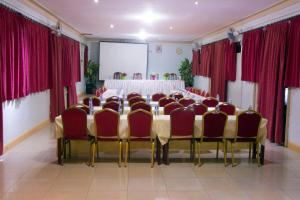 a conference room with a long table and red chairs at Comfort Hotel Entebbe in Lyamutundwe
