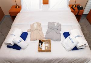 a white bed with towels and a tray with at Hotel Pelagos Studios in Platána