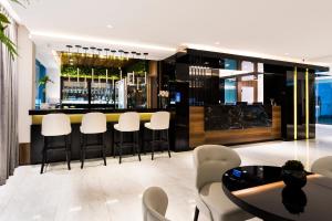 - un bar avec des chaises blanches et une table dans la chambre dans l'établissement Itacolomi Hotel, à Balneário Piçarras