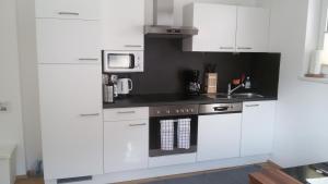a kitchen with white cabinets and a microwave at Ferienwohnung Marie in Oetz