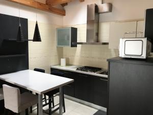 a kitchen with a white table and a microwave at Appartamento Primo in Padova