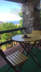 un tavolo e una panca sul balcone con vista di Villino Mamy a Costa Paradiso