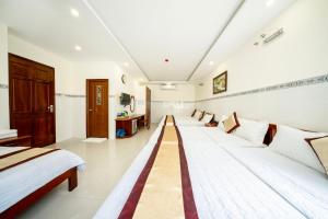 a large room with two beds and a couch at Binh Minh Hotel in Vung Tau