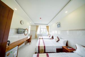 a hotel room with two beds and a desk at Binh Minh Hotel in Vung Tau +36 photos