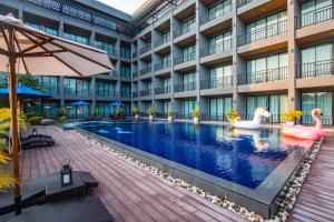 una imagen de una piscina de hotel con cisnes en Sun Marina Cha-Am en Cha Am