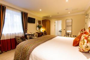 a hotel room with a large bed and a desk at Grand Hotel Tralee in Tralee