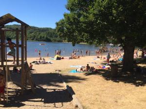 un grupo de personas en la playa en un lago en Studio duplex 1 Lac des Montagnès, en Mazamet