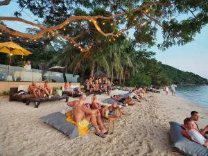 a group of people sitting on a beach at Sarikantang Resort & Spa, Koh Phangan in Haad Rin