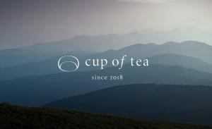 un logo de taza de té con montañas en el fondo en cup of tea, en Takayama