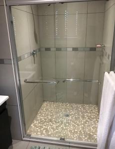 a shower with a glass door in a bathroom at Number Six in Durban