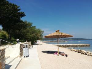 eine Person, die unter einem Sonnenschirm am Strand liegt in der Unterkunft Villa Bianca Karin in Gornji Karin