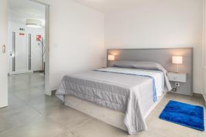 ポール・ド・マールにあるCasa das bonecas 2 # Private Garage Included #の白いベッドルーム(ベッド1台、青いラグ付)