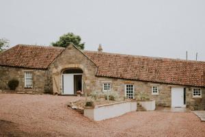 an old stone house with an open door at Orchard Cottage in St. Andrews