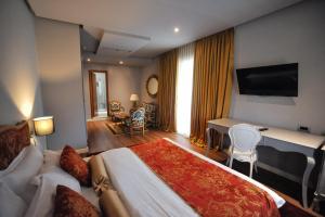 a hotel room with a large bed and a desk at Classic Hotel in Tirana