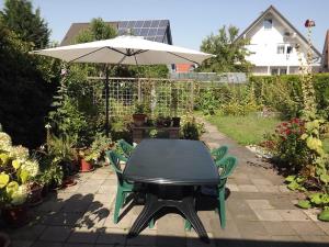 einen Tisch und Stühle mit Sonnenschirm in einem Garten in der Unterkunft Haus Bergglück in Hückelhoven