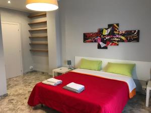 a bedroom with a large bed with red blanket and green pillows at CAVOUR 124 -guest-room- in Bari