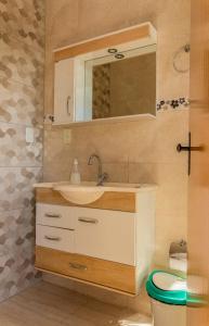 W łazience znajduje się umywalka, lustro i toaleta. w obiekcie Pouso Oliveira Suítes w mieście São João Batista do Glória