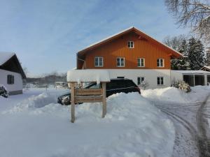 a sign in the snow in front of a house at Ferienwohnung Am Verlorenen Bach in Untermühlhausen