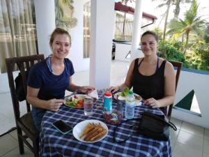 two women sitting at a table with a plate of food at The Finz in Hikkaduwa