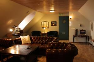 - un salon avec un canapé en cuir et une table dans l'établissement Österlens Karlsgård, à Löderup
