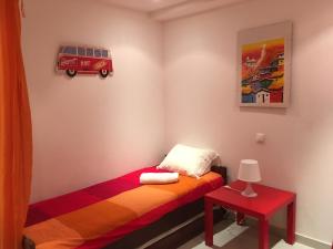 a small bedroom with a bed and a red table at Golden Beach Apartment, Cabanas - Rua das Giestas Lote 4 J in Cabanas de Tavira