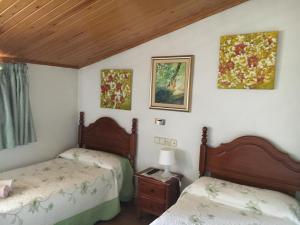 a bedroom with two beds and a table at Fonda Muntanya in Vilaller