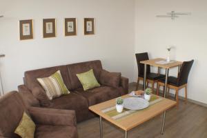 sala de estar con sofá marrón y mesa en Haus an der Therme en Bad Füssing